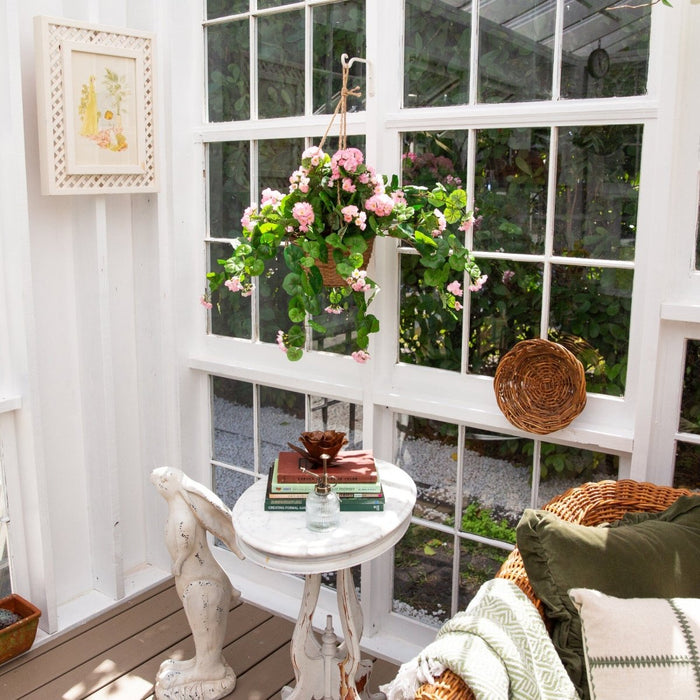 Cozy corner with a small table, chair, and decorative items in a sunroom.